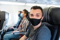 Airplane passengers are wearing medical masks on their faces. Air travel during the coronavirus pandemic. Airlines requirements Royalty Free Stock Photo