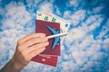 Airplane, passport and money in female hand - travelling concept Royalty Free Stock Photo