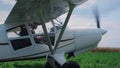 Airplane pilot turning off engine after landing on field. Man parking aircraft. Royalty Free Stock Photo