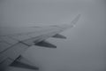Airplane right wing flying over cloudy gray day Royalty Free Stock Photo