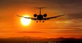 Airplane landing - private jet silhouette on sunset Royalty Free Stock Photo