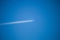 The airplane in the sky and the cluster of clouds left, the plane in the blue sky, and the cluster of clouds that it leaves.