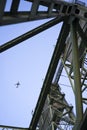 The plane flies over the triangular frames of the lifting bridge