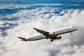 Airplane in the sky full of fluffy clouds Royalty Free Stock Photo