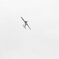 Airplane in the sky. Minimalism. Aerobatics figure. White square
