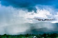 Airplane in the sky with rain over mountain, The plane flies in terrible thunderstorm