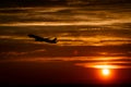 Airplane at sunset sky in the air with space for text. Silhouette of a big passenger aircraft in sun light. transportation Royalty Free Stock Photo