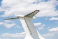Airplane tail close-up. Aircraft part against blue sky with clouds background. Copyspace