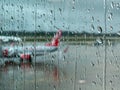 Airplane tailfin looking through raindrops on a glass window Royalty Free Stock Photo