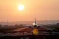 Airplane taking off at an airport at sunset Royalty Free Stock Photo