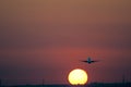 Airplane taking off at Seville airport at sunset with yellow sun Royalty Free Stock Photo