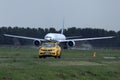 Airplane taxiing on runway and airport security car