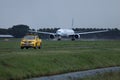 Airplane taxiing on runway and airport security car in AMS Airport Royalty Free Stock Photo