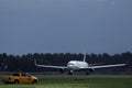 Airplane taxiing on runway and airport security car in AMS Airport Royalty Free Stock Photo