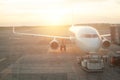 Airplane at the terminal gate. Modern international airport during sunset background Royalty Free Stock Photo