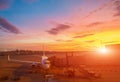 Airplane at the terminal gate ready for takeoff. International airport during colorful sunset - Concept  Travel around the world Royalty Free Stock Photo