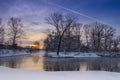 Airplane trace over the river fog. Colours of winter sunset