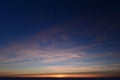 Airplane trail in the blue sky in white cirrus clouds in winter at sunset