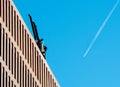 Airplane trail create a rectangular shape with modern office building and a crane. Royalty Free Stock Photo