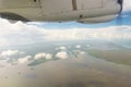 Airplane transport concept. View on the left wing passenger aircraft.Below the thick clouds illuminated by the sun.Horizontal view Royalty Free Stock Photo