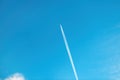 Airplane vapor trail or contrail pattern on blue sky with clouds Royalty Free Stock Photo