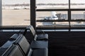 Airplane, view from airport terminal with empty seats in the airport waiting room near the gate. Travel concept Royalty Free Stock Photo