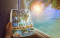 Airplane window with beautiful views of turquoise clear sea, palm trees and bright sunrise