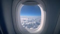 Airplane window with blue sky and clouds outside. Royalty Free Stock Photo