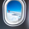 Airplane window that flies above the clouds Royalty Free Stock Photo