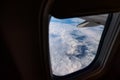 Airplane window from inside. Through the window you can see clouds and airplane wing. Royalty Free Stock Photo