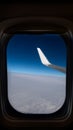 Airplane window from inside. Through the window you can see clouds, airplane wing, horizon and space. Royalty Free Stock Photo