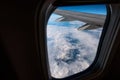 Airplane window from inside. Through the window you can see clouds and airplane wing. Royalty Free Stock Photo