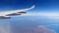 Airplane Window Seat -with beautiful view of wing of plane on flight and traveling in air over city and clouds.