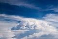 Airplane window seat view of big white thick fluffy clouds with a clear blue sky. Royalty Free Stock Photo