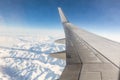 Airplane window seat view while flying over snowy mountains Royalty Free Stock Photo