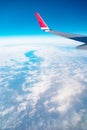 Airplane window view with a wing and curved Earth below bright sky heaven