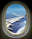 Airplane window wing view and cloudy blue sky Royalty Free Stock Photo
