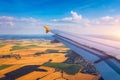 Airplane windows view above the earth on landmark down. View from an airplane window over a wing flying high above farmlands and Royalty Free Stock Photo