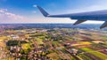 Airplane windows view above the earth on landmark down. View from an airplane window over a wing flying high above farmlands and Royalty Free Stock Photo