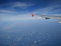 The airplane wing above the blue cloudy sky, view from the airplane`s window