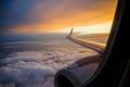 Airplane wing above clouds with divine sunset sunrise Royalty Free Stock Photo