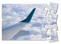 Airplane wing above the clouds in jigsaw puzzle shape