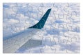 Airplane wing above the clouds in jigsaw puzzle shape