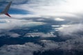 Airplane wing, aerial view with clouds and blue sky Royalty Free Stock Photo
