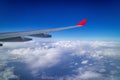 Airplane wing and aerial view during flight with clear blue sky and clouds Royalty Free Stock Photo