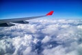 Airplane wing and aerial view during flight with clear blue sky and clouds Royalty Free Stock Photo