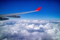 Airplane wing and aerial view during flight with clear blue sky and clouds Royalty Free Stock Photo