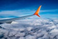 Airplane wing in blue sky above white fluffy clouds. Passenger transport flies in the atmosphere against the backdrop of a natural Royalty Free Stock Photo