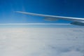 Airplane wing and cloudscape view out from window of airplane flying over earth ground. Royalty Free Stock Photo