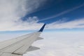 Airplane wing and dark blue sky with white clouds in flight Royalty Free Stock Photo